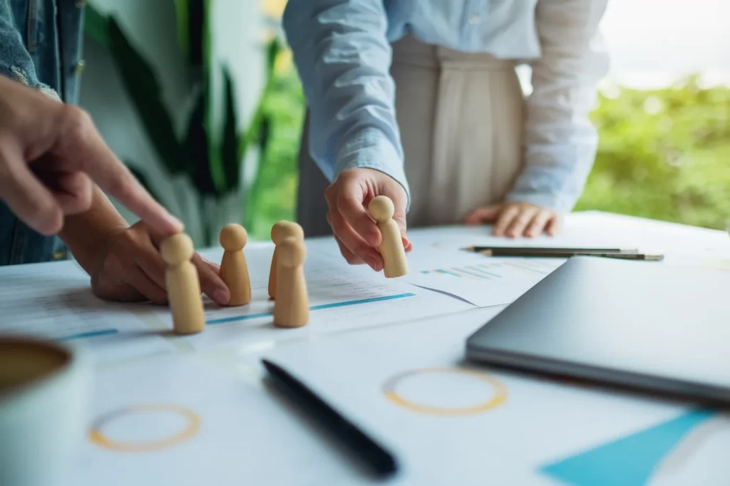 Personas utilizando piezas de ajedrez, representando una agencia experta